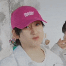 a man wearing a pink hat and a white shirt is looking at something .