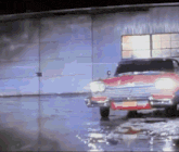a red car with a license plate that says ' nc ' on it is parked in front of a building