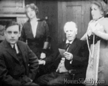 a group of people are sitting around a table in a room .