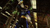 a man in a blue and gold superhero costume stands in a warehouse
