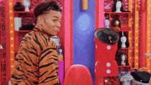 a man wearing a tiger print shirt is standing in front of a mannequin