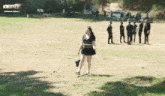 a cheerleader is standing in a field with a howcast tv logo