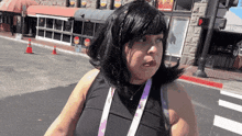 a woman wearing a lanyard with the word disney on it walks down a street