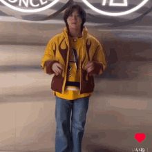 a man in a yellow jacket is dancing in front of a sign that says ' once ' on it