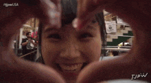 a person making a heart shape with their hands in front of a sign that says daido
