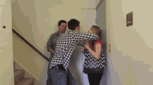 a man in a plaid shirt is hugging a woman in a black and white bag