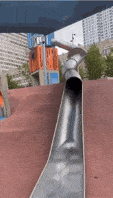 a stainless steel slide is going down a red hill