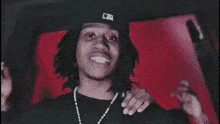 a group of people are dancing in a dark room with a red wall in the background .