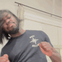 a man with a beard wearing a black shirt that says bellot