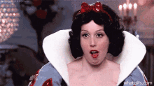 a woman is dressed as snow white from snow white and the seven dwarfs and is making a funny face .