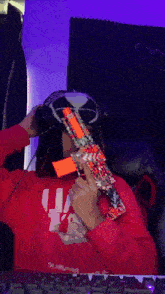 a person wearing a red sweatshirt that says ua on it