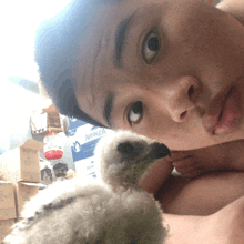 a man laying down with a baby bird in front of a stack of boxes that say miranda