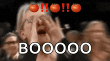 a woman is screaming in a crowd with tomatoes on her head and the word booo on the bottom .