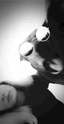 a black and white photo of a woman wearing sunglasses