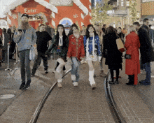 a group of people walking in front of a gingerbread house that says enter