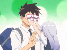 a man and a girl are playing a game of cards and the girl is putting cards on the man 's face