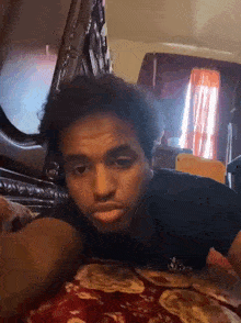 a man is laying on his stomach on a bed and making a face .