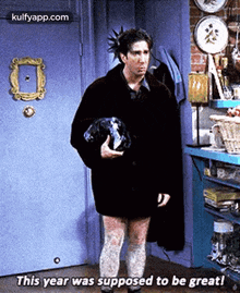 a man is standing in front of a door holding a dog and says this year was supposed to be great .