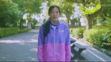 a woman wearing a pink and purple jacket that says yonex