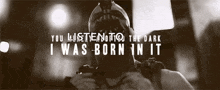 a black and white photo of a man in a gas mask with the words you listen to the dark i was born in it