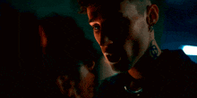 a close up of a woman 's face with a man 's face in the background