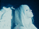 a woman with white feathered wings looks up at the sky