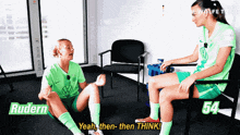 two female soccer players are sitting on the floor and one of them is wearing a vw shirt