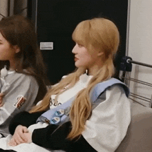 a woman with blonde hair is sitting next to another woman
