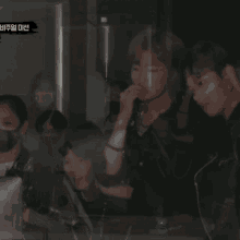 a group of people in a dark room with a yellow sign that says ' a ' on it