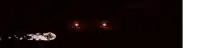 a skeleton is standing in a dark room with a light coming out of its mouth .