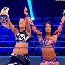 two women in a wrestling ring with one wearing a top that says pay ley