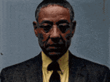 a man in a suit and tie with glasses looks at the camera