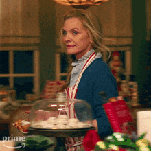 a woman in an apron is holding a tray of cookies and the word prime is on the bottom right