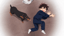 a boy is laying on the floor with a black dog behind him