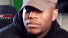 a man wearing a hat and hoodie is making a funny face .