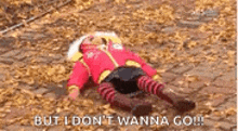 a person is laying on the ground covered in leaves with the words `` but i don 't wanna go '' .