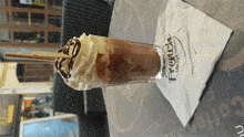 a french coffee shop napkin sits next to a drink