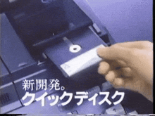 a close up of a person 's hand pressing a button on a machine with asian writing on it