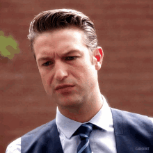 a man in a suit and tie has the word carisibot on the bottom of his shirt