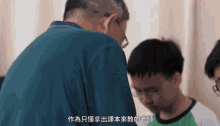a man in a green shirt talks to a young boy in a green shirt