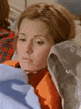a woman laying on a bed with a blue blanket