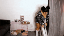a woman wearing headphones is standing in front of a dog crate