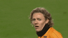 a soccer player wearing an orange jersey with the name bullard on the back