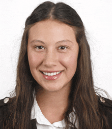 a woman with long brown hair is smiling and wearing a white shirt