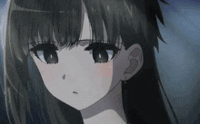 a close up of a girl 's face with long black hair