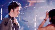 a man and a woman are dancing on a stage .