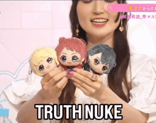 a woman is holding three stuffed dolls and says " truth nuke " on the bottom