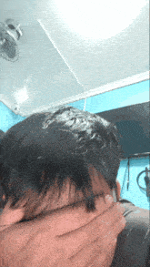 a person covering their face with their hand in a room