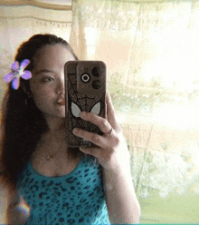 a woman is taking a selfie in front of a mirror with a spider-man phone case .
