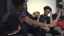 a group of men are sitting on a couch laughing